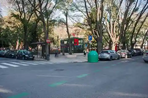 Entrada de metro em Lisboa, com estacionamento, rua e espaço urbano envolvente.